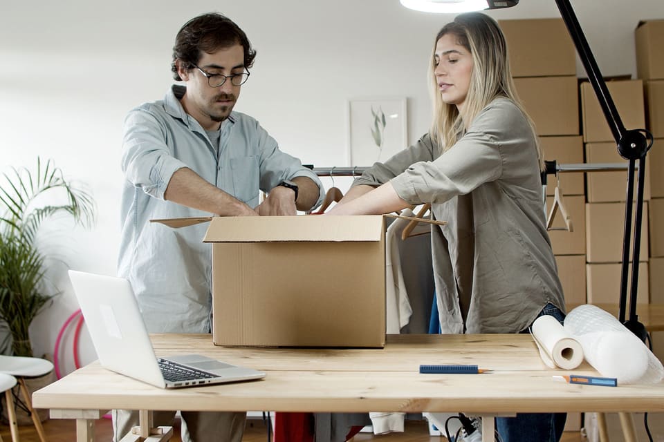 Two people packing an order together at a worktable.